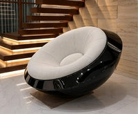 UFO chair with glossy black shell and cream boucle seat in a luxury living room